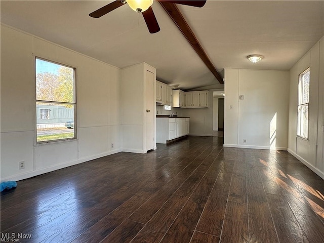 unfurnished living room with lofted ceiling with beams, ceiling fan, and dark hardwood / wood-style flooring