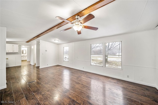 unfurnished living room with dark hardwood / wood-style floors, plenty of natural light, and beam ceiling