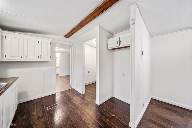 interior space with beamed ceiling and dark hardwood / wood-style floors