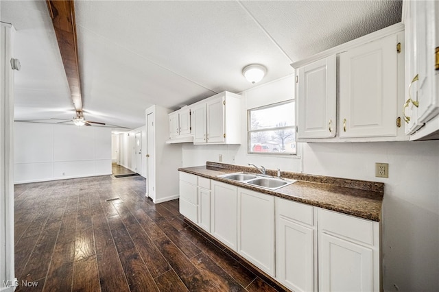 kitchen featuring sink, dark wood-type flooring, ceiling fan, vaulted ceiling with beams, and white cabinets