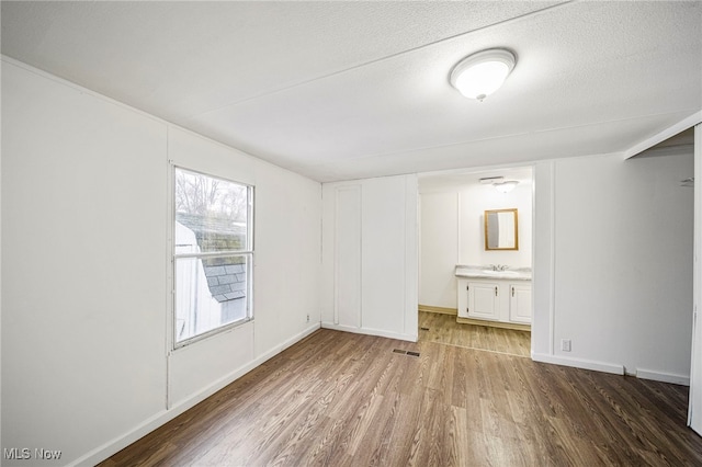 spare room with hardwood / wood-style flooring and a textured ceiling