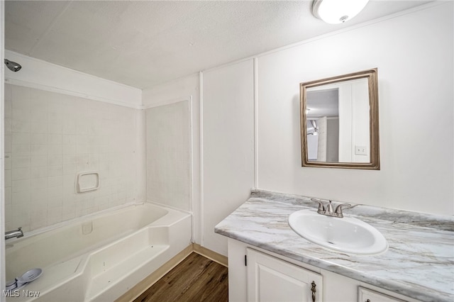 bathroom with vanity, tub / shower combination, hardwood / wood-style floors, and a textured ceiling