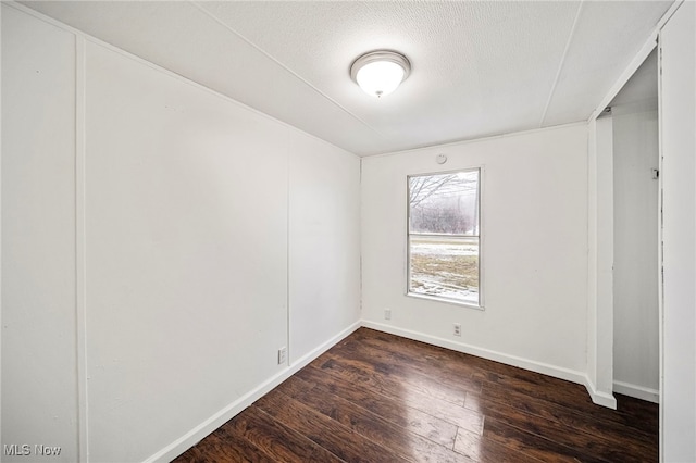 spare room with dark wood-type flooring and a textured ceiling