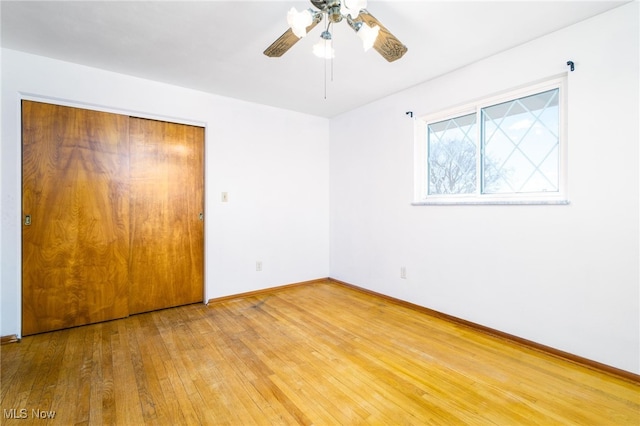 unfurnished bedroom with hardwood / wood-style flooring, ceiling fan, and a closet