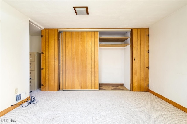 unfurnished bedroom featuring light carpet and a closet