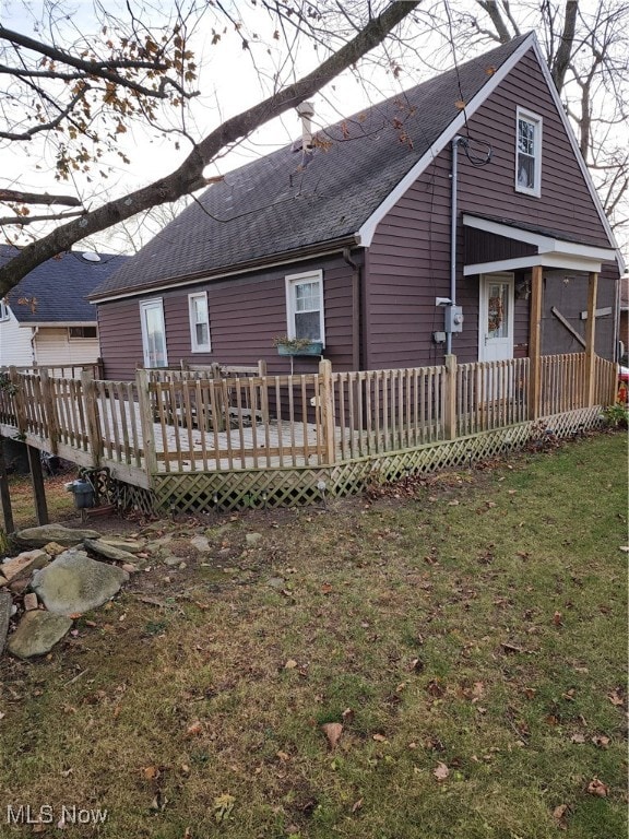 rear view of house with a deck and a lawn