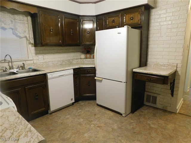 kitchen featuring dark brown cabinetry, white appliances, and sink