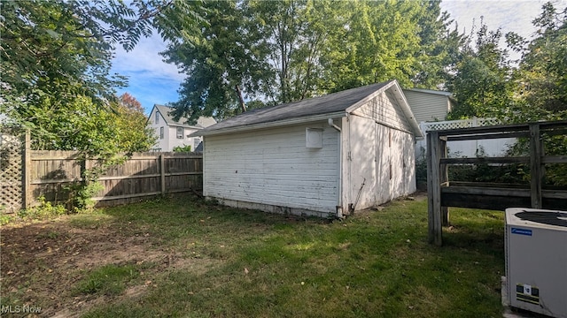 view of outdoor structure with central AC and a yard