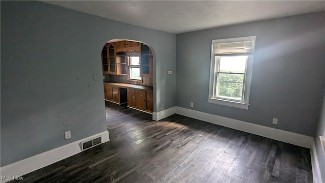 unfurnished room with a healthy amount of sunlight and dark hardwood / wood-style floors