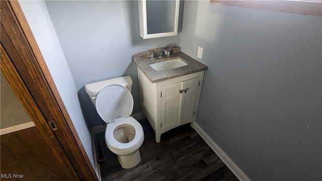 bathroom with hardwood / wood-style floors, vanity, and toilet