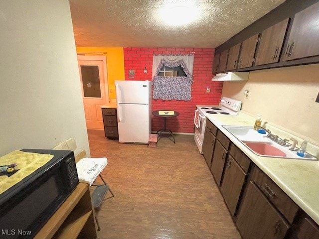 kitchen with white appliances, dark brown cabinets, a textured ceiling, and sink