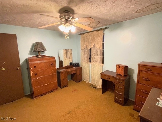 office space with ceiling fan, a textured ceiling, and light colored carpet