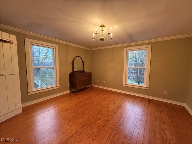 interior space with ornamental molding, light hardwood / wood-style floors, a healthy amount of sunlight, and a chandelier