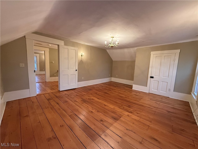 bonus room with light hardwood / wood-style floors, an inviting chandelier, and lofted ceiling