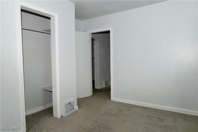 unfurnished bedroom with a closet and light colored carpet