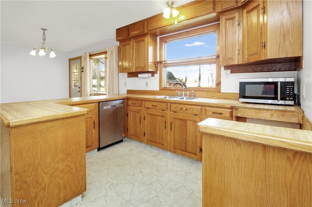 kitchen with wood counters, stainless steel appliances, sink, decorative light fixtures, and an inviting chandelier