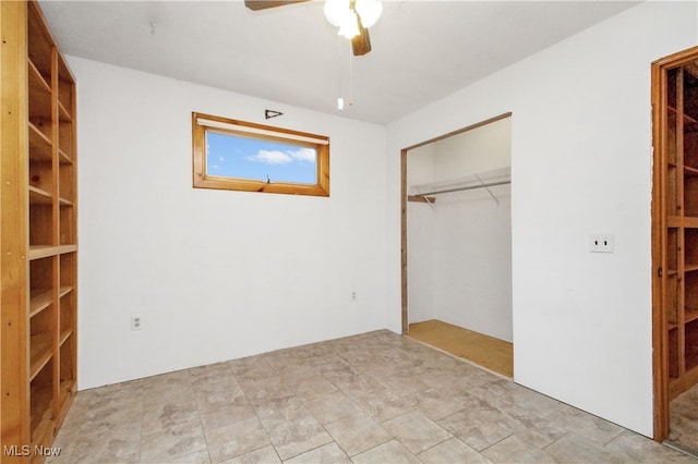 unfurnished bedroom with ceiling fan and a closet