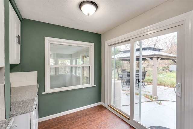 doorway with wood-type flooring and a textured ceiling