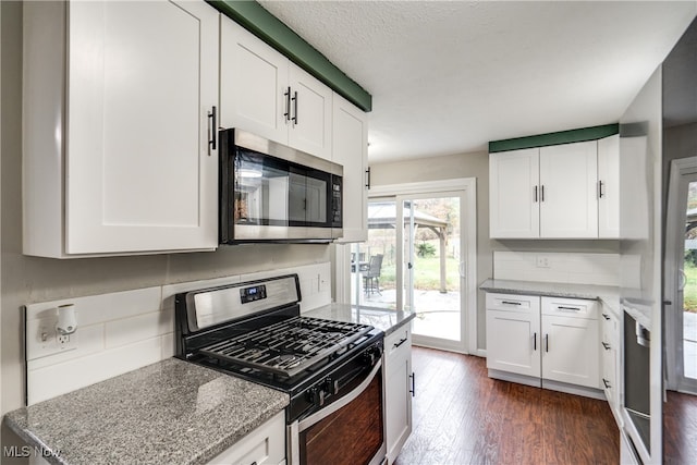 kitchen featuring white cabinetry, dark hardwood / wood-style flooring, light stone counters, and appliances with stainless steel finishes