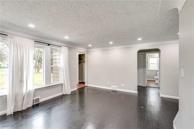 spare room featuring dark hardwood / wood-style flooring and a textured ceiling