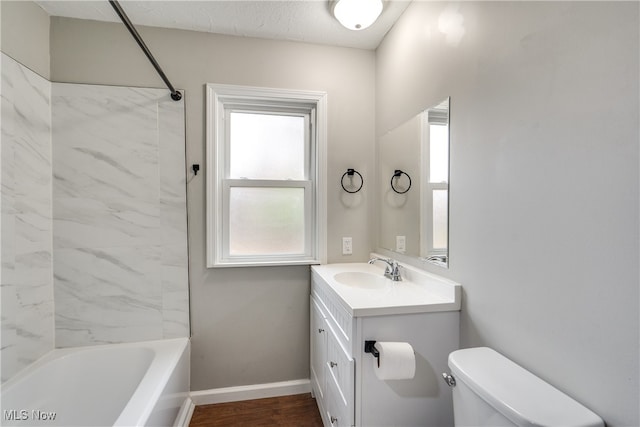 full bathroom featuring vanity, hardwood / wood-style floors, toilet, and tiled shower / bath combo