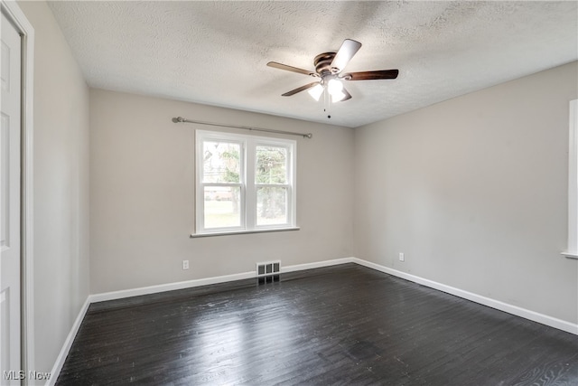 empty room featuring ceiling fan, dark wood-type flooring, and a textured ceiling