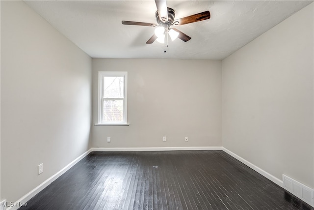 empty room with ceiling fan and dark hardwood / wood-style floors