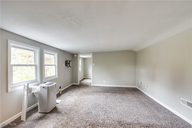 carpeted empty room with a textured ceiling