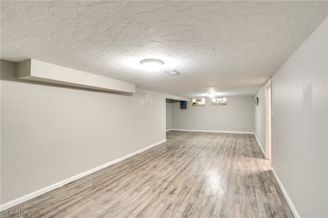 basement featuring hardwood / wood-style floors and a textured ceiling