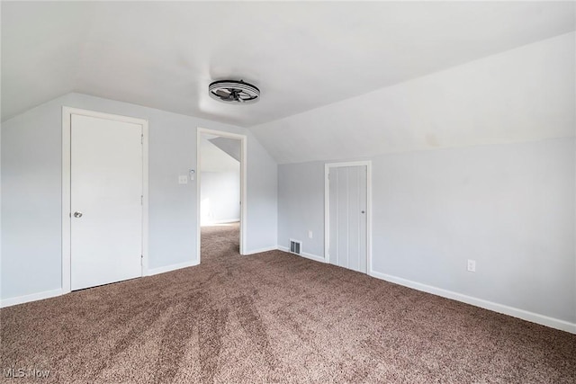 additional living space featuring lofted ceiling and carpet flooring