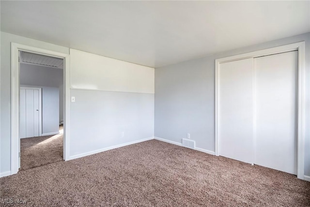 unfurnished bedroom with a closet and carpet flooring