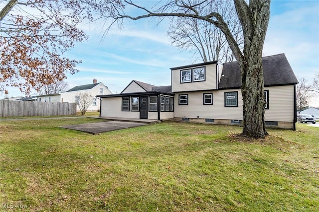 rear view of property with a lawn, a sunroom, and a patio