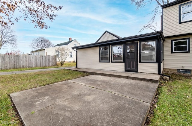 rear view of house with a patio and a lawn