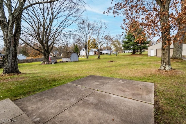 view of yard with a storage shed and a patio