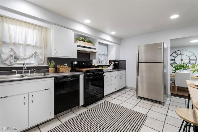 kitchen featuring white cabinetry, sink, light tile patterned floors, and black appliances