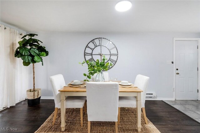 dining space with dark hardwood / wood-style flooring and baseboard heating