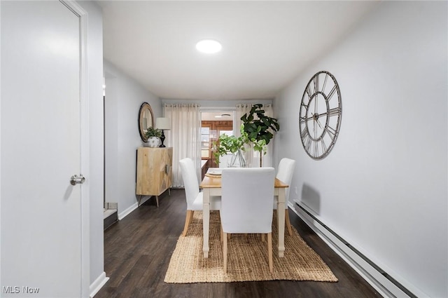 dining space with dark hardwood / wood-style flooring and baseboard heating