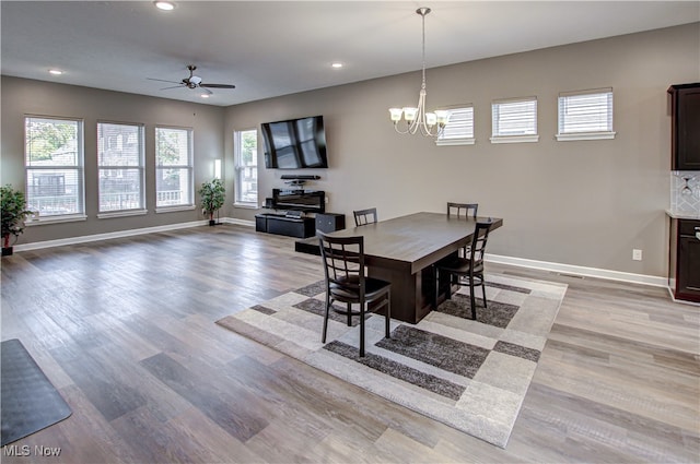 dining area with ceiling fan with notable chandelier and light wood-type flooring