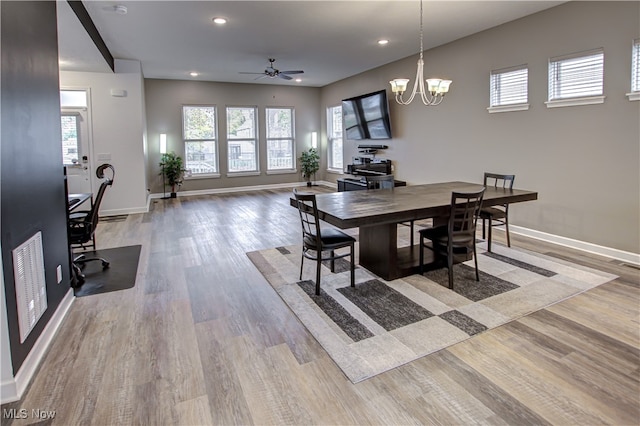 dining room featuring light hardwood / wood-style flooring and ceiling fan with notable chandelier