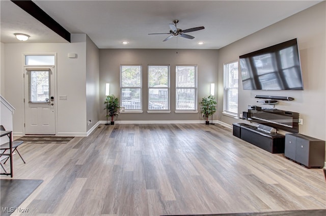 living room with a wealth of natural light, ceiling fan, and wood-type flooring