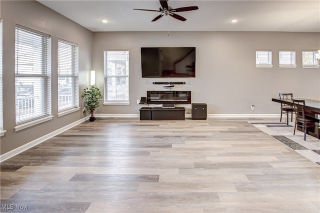 living room featuring ceiling fan, plenty of natural light, and light wood-type flooring