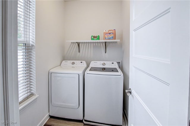 laundry room with washer and dryer and wood-type flooring