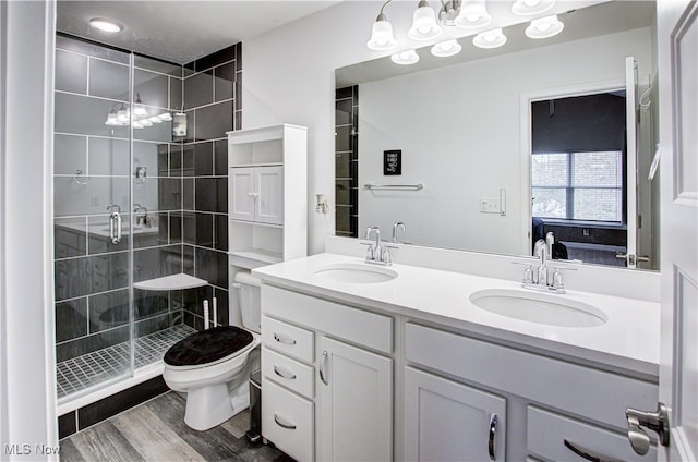 bathroom featuring vanity, an enclosed shower, toilet, and hardwood / wood-style flooring