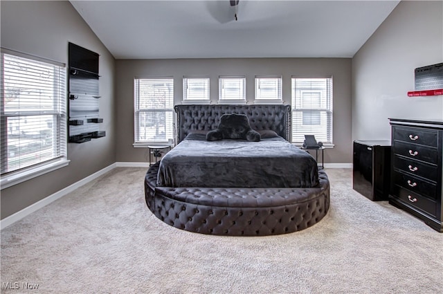 bedroom featuring multiple windows, light colored carpet, and vaulted ceiling