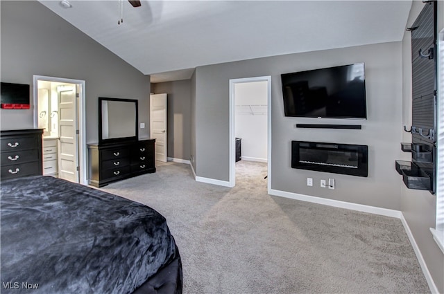 carpeted bedroom featuring vaulted ceiling, a spacious closet, a closet, and ceiling fan