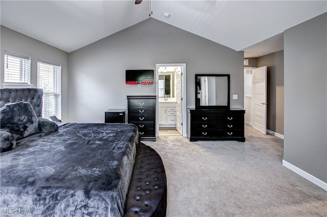 carpeted bedroom with connected bathroom, ceiling fan, sink, and lofted ceiling