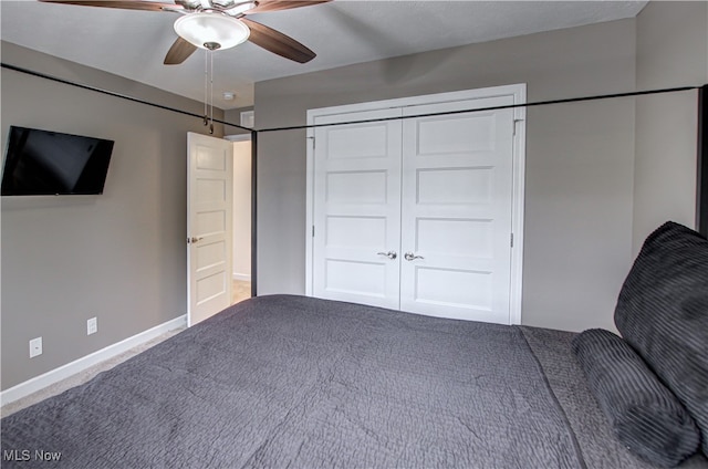 unfurnished bedroom featuring ceiling fan, a closet, and carpet floors