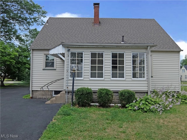 rear view of house featuring a lawn