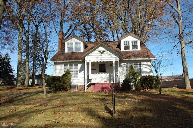 new england style home with a front yard and cooling unit