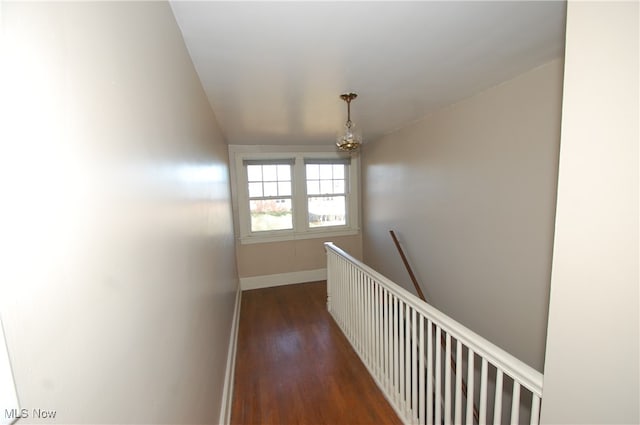 hall with dark hardwood / wood-style floors and an inviting chandelier